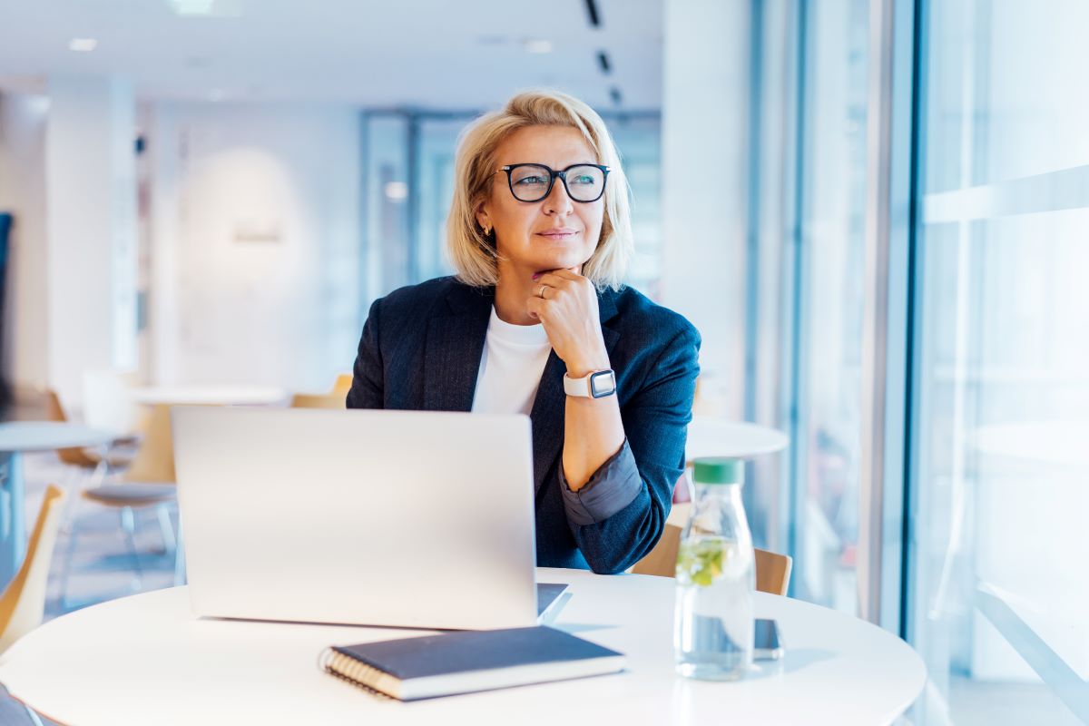 Mature businesswoman dreamy looking at  a window